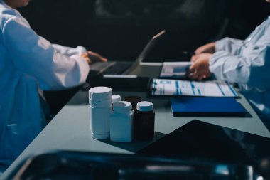 Erkek ve kadın doktorlar bir hastane odasında toplantı yapıyorlar..