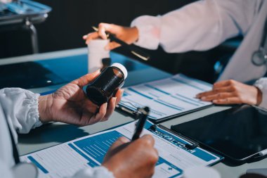 Erkek ve kadın doktorlar bir hastane odasında toplantı yapıyorlar..