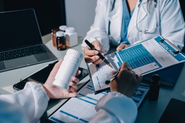 Erkek ve kadın doktorlar bir hastane odasında toplantı yapıyorlar..