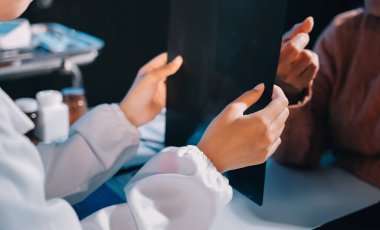 Doktor, emekliye ayrılmış yaşlı kadına akciğer röntgeni çeken hastanın sağlık ve hayat sigortası planlarını kullanarak hastane bakım evindeki hastalara tedavi yöntemlerini anlattı.