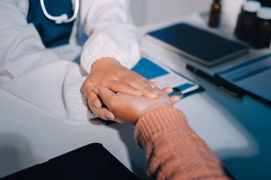 Asyalı kadın elleri yaşlı kadın ellerine dokunuyor hastanede yaşlılara yardım eden eller.