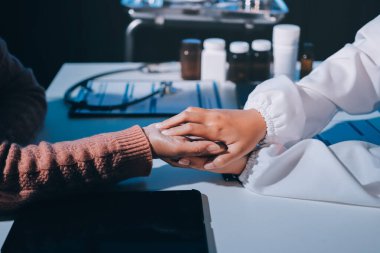 Asyalı kadın elleri yaşlı kadın ellerine dokunuyor hastanede yaşlılara yardım eden eller.