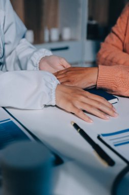 Asyalı kadın elleri yaşlı kadın ellerine dokunuyor hastanede yaşlılara yardım eden eller.