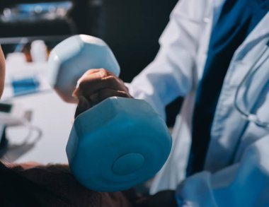 Klinikte dambıllar, fizik tedavi konsepti kullanan hastalarla fizyoterapist eğitimi