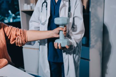 Klinikte dambıllar, fizik tedavi konsepti kullanan hastalarla fizyoterapist eğitimi