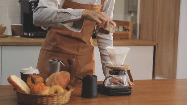 Genç barista bir kafede kahve yapıyor, kahvesini hazırlıyor.