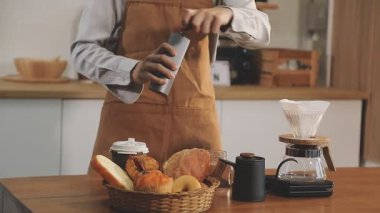 Kahveyi mutfaktaki tezgahın üstüne koyan barmen.