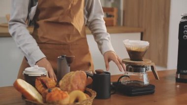 Genç barista kahve dükkanında sütlü espresso kahvesi hazırlıyor..