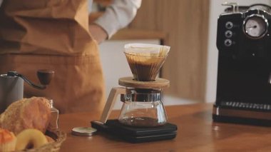 Barista bardağa taze kahve dolduruyor.