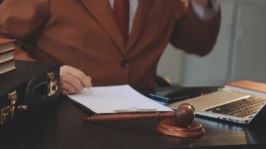 Avukat ya da hakim avukat tokmak ve dizüstü bilgisayarla büroda ya da avukatın masasında çalışıyor, hukuki hizmet kavramı.