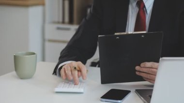 Ofisteki genç işadamı dizüstü bilgisayarı ve bir fincan kahveyle