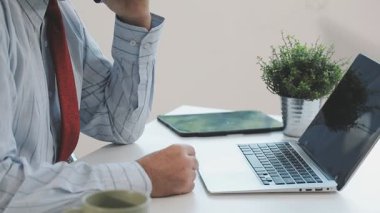 İş konsepti. Akıllı telefon ve laptop kullanan bir adam..