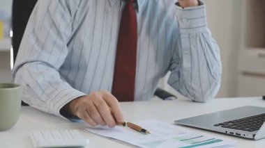 Ofiste çalışan bir iş adamı, laptop kullanıyor.