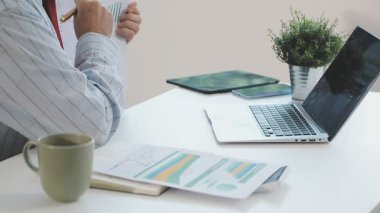 Finansal grafiği ve dizüstü bilgisayarı olan bir iş adamı