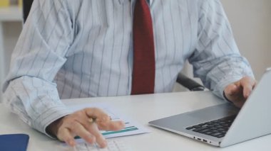 Dizüstü bilgisayarı ve hesap makinesi olan iş adamı