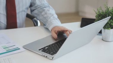 Yakın plan. Ofiste dizüstü bilgisayarla çalışan bir adamın eli.