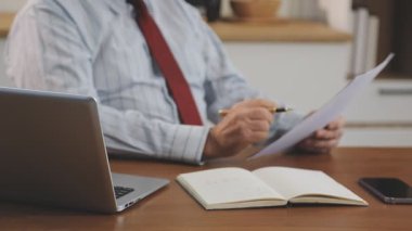 Takım elbiseli işadamı ofiste dizüstü bilgisayarla çalışıyor..