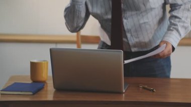 Ofiste laptopla çalışan bir adam.