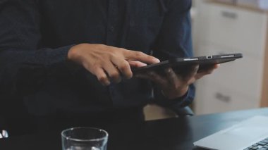 Adam evde çalışırken akıllı telefon kullanıyor.