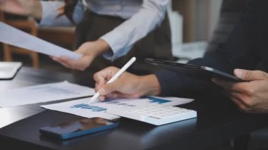 İş yerinde doküman ve hesap makinesiyle çalışan genç iş adamını kapatın.