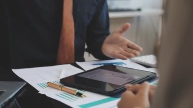 Genç Asyalı işadamı ofiste tablet bilgisayarla çalışıyor. İş adamları modern ofiste çalışır..