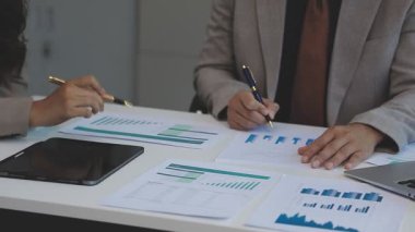 Masada mali tablolarla çalışan bir işadamı.