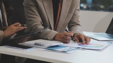 Ofiste dizüstü bilgisayar ve hesap makinesiyle çalışan iş kadınları.