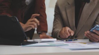 Ofiste akıllı telefon kullanan genç iş adamları