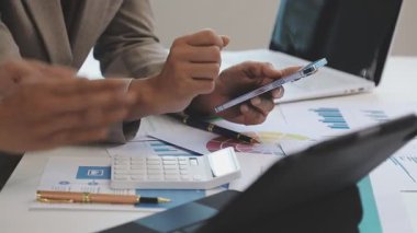 Masa başında mali tablolarla çalışan iş ekibi..