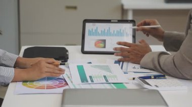 İşadamı, ofiste mali verileri olan dijital tablet kullanıyor.