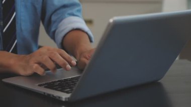 Adam dizüstü bilgisayar kullanıyor ve ofiste çalışıyor.