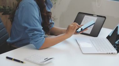 Laptop ve tablet bilgisayar kullanan genç bir kadın