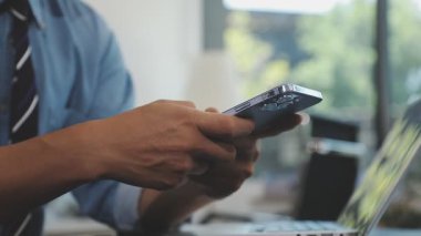 Yakın plan. Ofiste akıllı telefon kullanan bir adamın fotoğrafı..