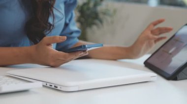 Evde kredi kartı ve tableti olan bir kadın var.