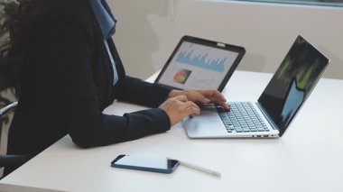 Ofisteki dizüstü bilgisayarda çalışan genç kadın.