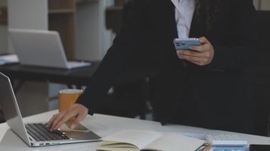 Ofiste dizüstü bilgisayarla çalışan bir kadın.