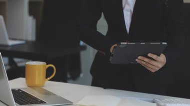 Ofiste elinde tablet tutan bir iş kadını.