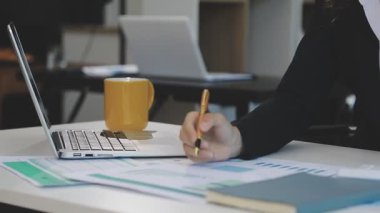 İş kadını ofiste defter ve bilgisayarla, iş ve eğitimle çalışıyor