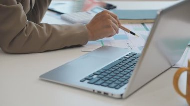 Dizüstü bilgisayarda çalışan genç bir kadın.