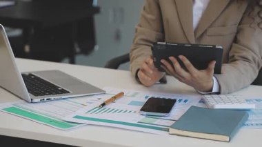 İş adamları dizüstü bilgisayarda çalışıyor ve iş yerinde mali planı tartışıyorlar.