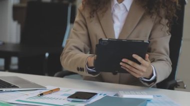 Ofiste elinde tablet olan genç bir kadın..