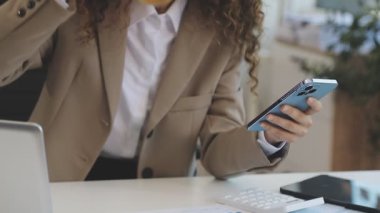 Hesap makinesi ve çay kullanan bir iş kadını..