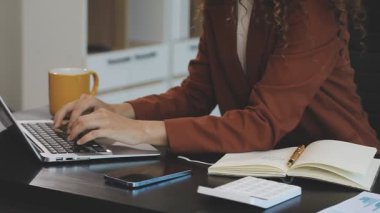 İş kadını ofisteki masasında çalışmak için dizüstü bilgisayar kullanıyor..