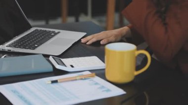 Ofiste bilgisayar ve hesap makinesiyle çalışan bir kadın. iş ve teknoloji kavramı