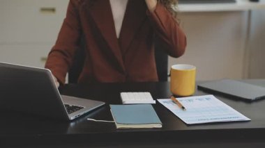 İş kadını ofiste dizüstü bilgisayar kullanıyor.