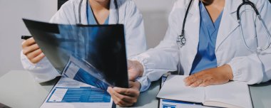 Erkek ve kadın doktorlar bir hastane odasında toplantı yapıyorlar..