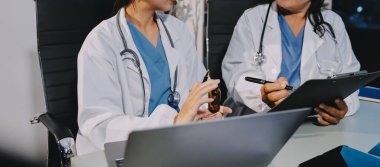 Erkek ve kadın doktorlar bir hastane odasında toplantı yapıyorlar..