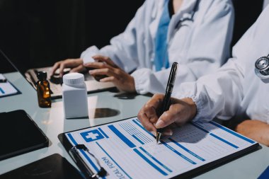 Erkek ve kadın doktorlar bir hastane odasında toplantı yapıyorlar..