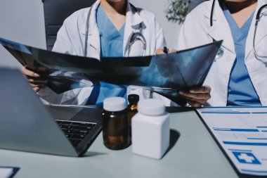 Erkek ve kadın doktorlar bir hastane odasında toplantı yapıyorlar..