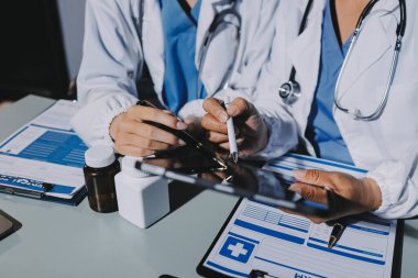 Erkek ve kadın doktorlar bir hastane odasında toplantı yapıyorlar..